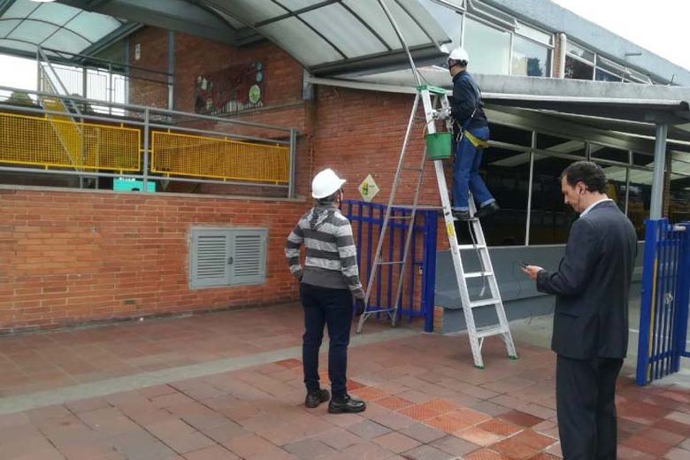 Operarios con escalera limpiando una fachada en Sogamoso